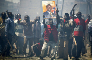 Opposition supporters holding a poster of their leader Raila Odinga of Orange Democratic Movement (ODM) react during post election ethnic violence in Nairobi, January 2, 2008. President Mwai Kibaki's government accused rival Raila Odinga's party of unleashing "genocide" in Kenya on Wednesday as the death toll from tribal violence over a disputed election passed 300. REUTERS/Stringer (KENYA) KENYA OUT